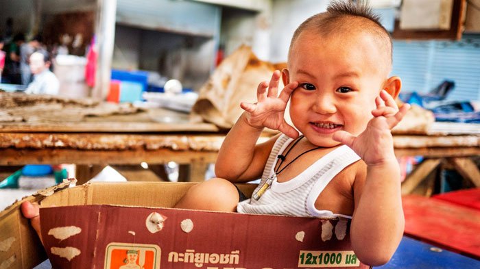 Thai kid in a box mimicing the photographer during a Chiang Mai Photo Workshop