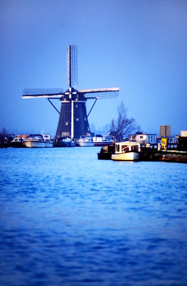 Old windmill near river in Holland.