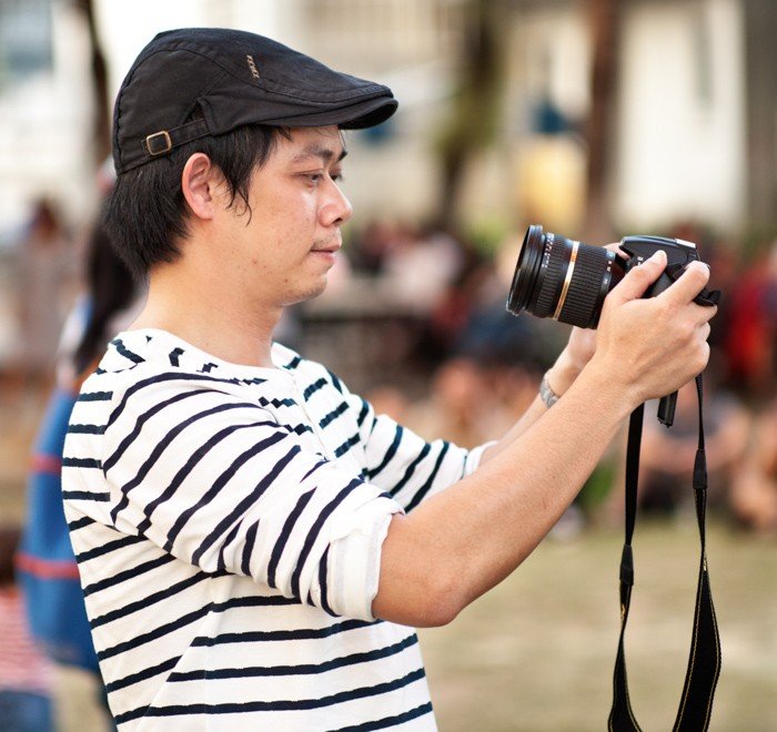 Man takes a selfie with a DSLR camera. Tips For Travel Photography etiquette in Thailand