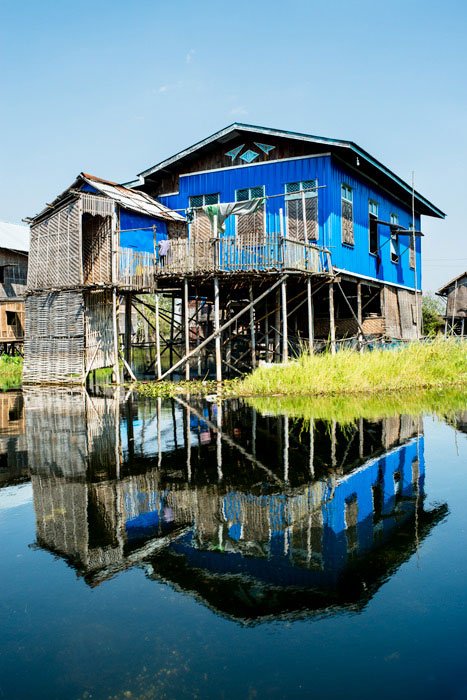 Blue house and reflection at Inle lake, Myanmar photographs in the middle of the day
