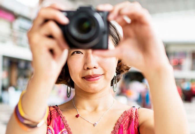 Asian woman taking a photo with a camera