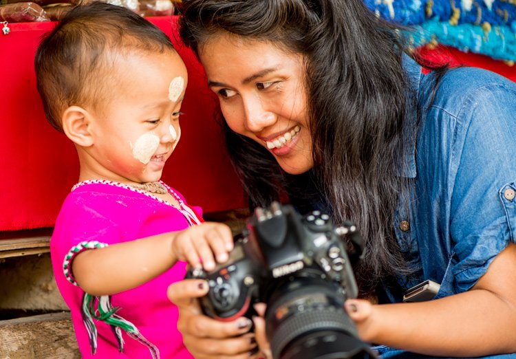 Thai woman and Kayan child with a camera