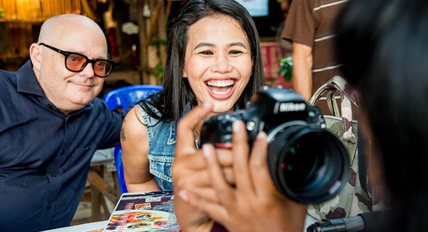 Two pretty women one with a DSLR camera