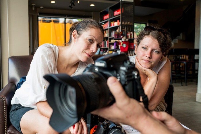 Two women on a photography workshop being shown the functions of a DSLR camera
