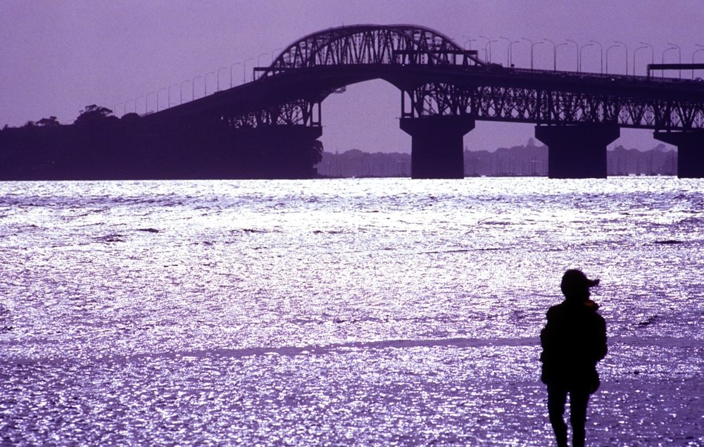 Harbour bridge, Auckland, New Zealand in silhouette with person in foreground. how to photograph people