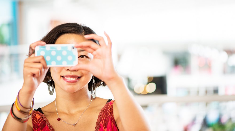 woman using a smart phone to take a photograph. © Kevin Landwer-Johan