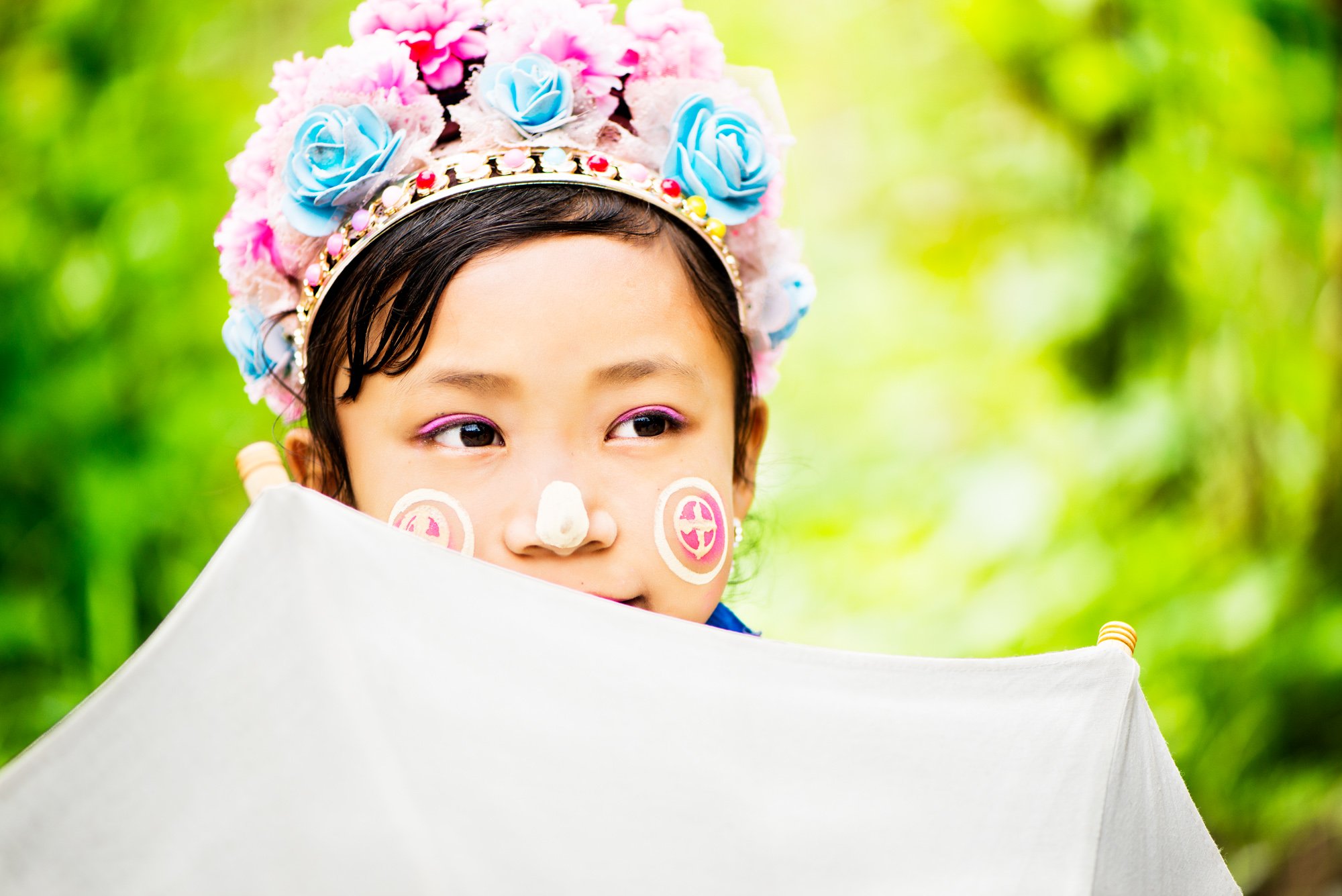 Kayan girl with a parasol thinking about photography terms