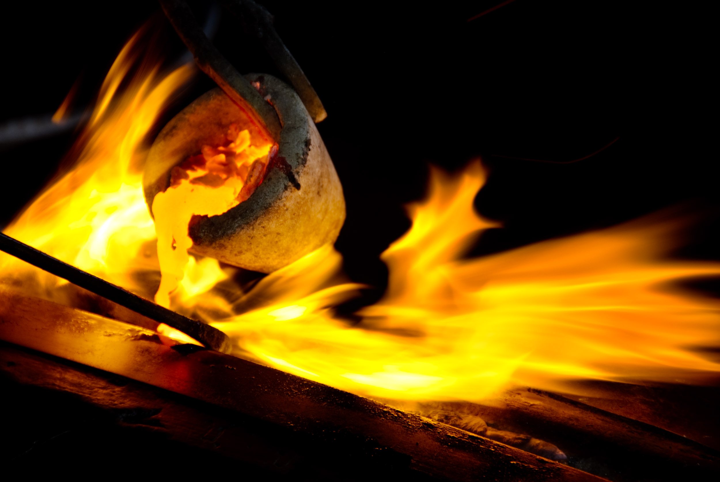Small crucible pouring moulten bronze at a foundry. For Photography Mentorship Program