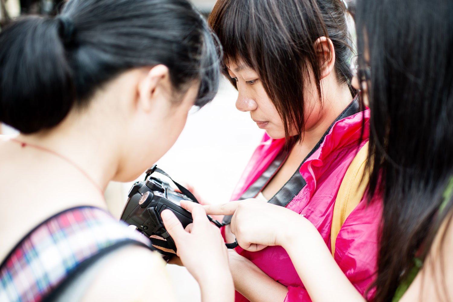 Three Asian women choosing the best camera