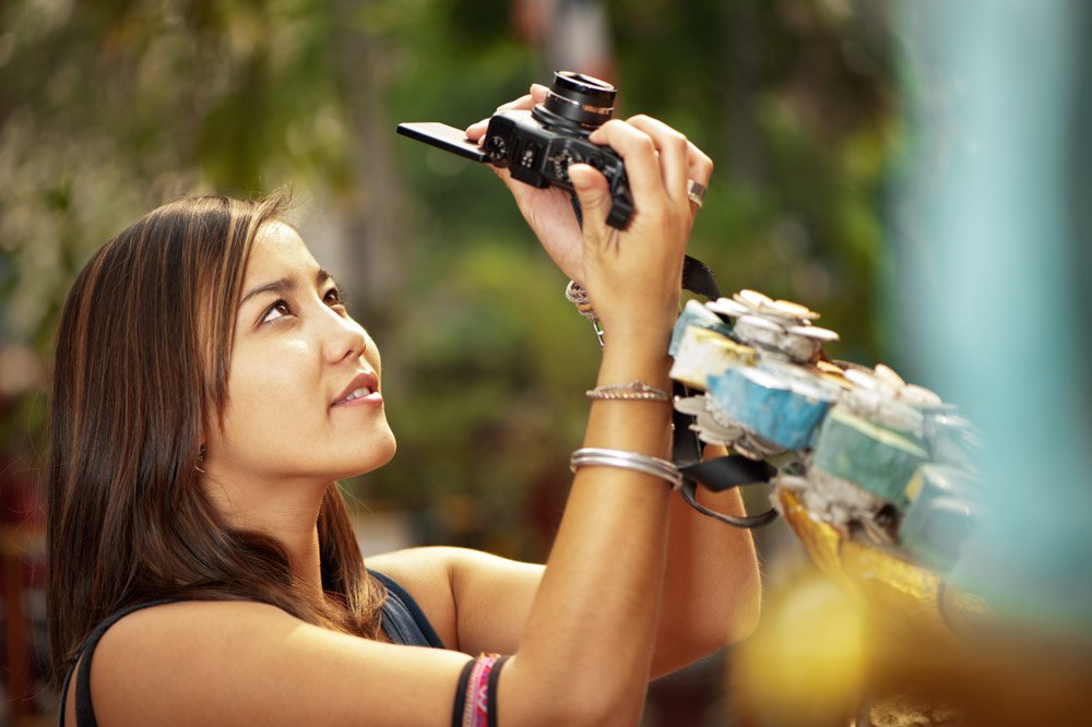 Young woman taking a photo with a new camera © Kevin Landwer-Johan