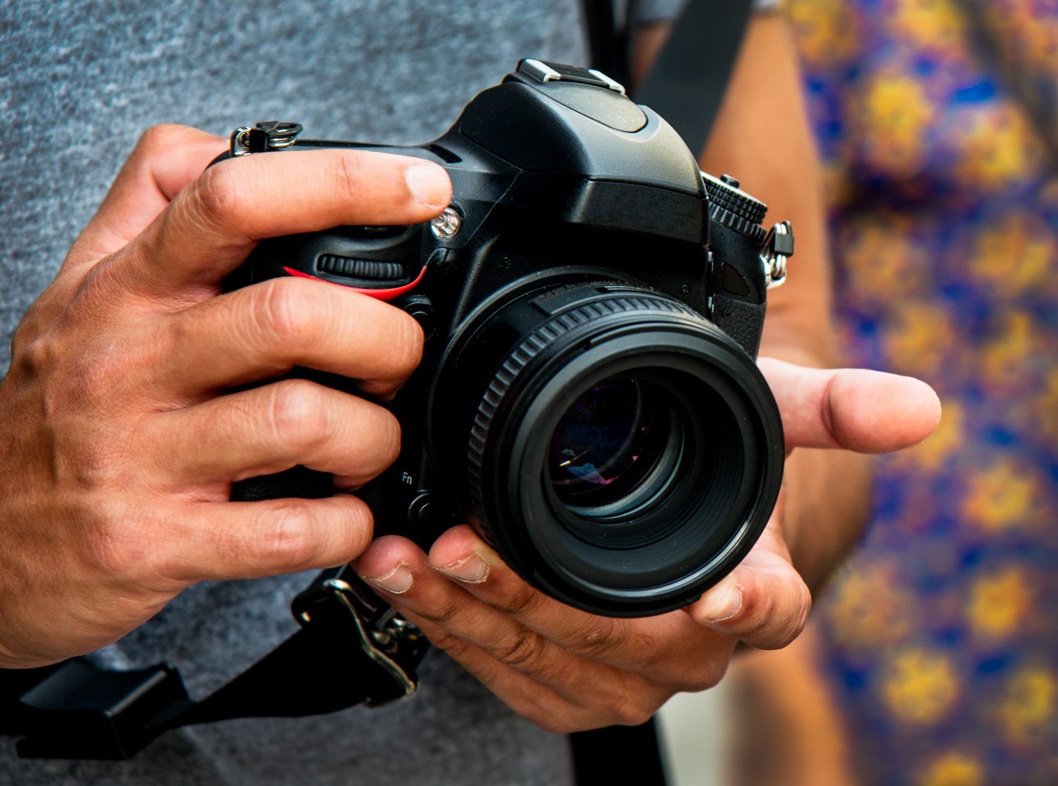 close up of a person holding a DSLR camera for photography terms camera, hand held